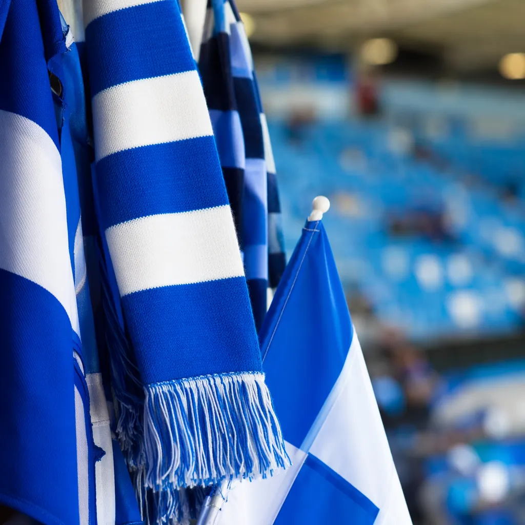 Close up of colorful football fan merchandise including scarves and flags in blu