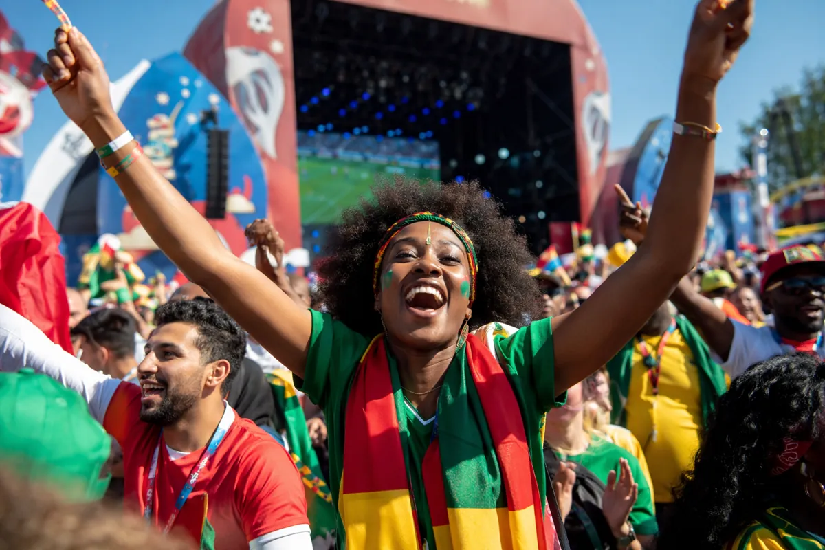 Vibrant scene of World Cup fan festival, excited diverse football fans cheering in front o