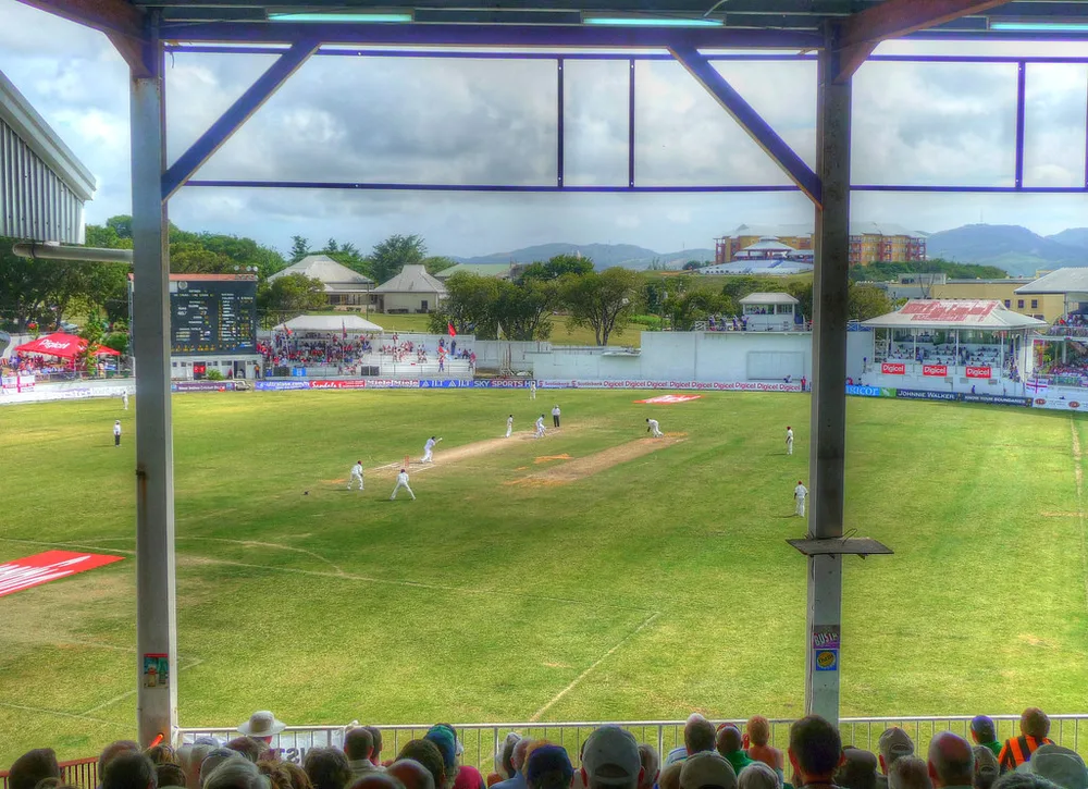 Wide shot of football stadium stands with cheering fans, colorful national flags