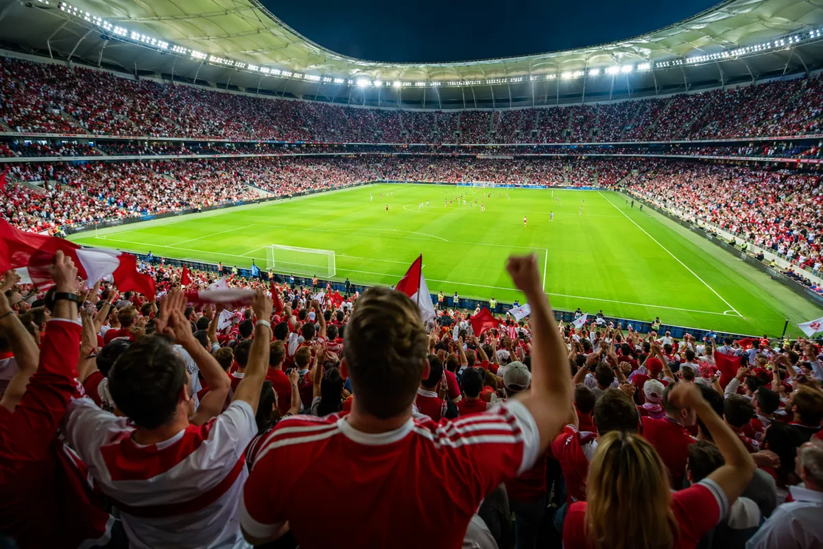 A vibrant wide shot of a football stadium during a World Cup match, with cheering fans wea