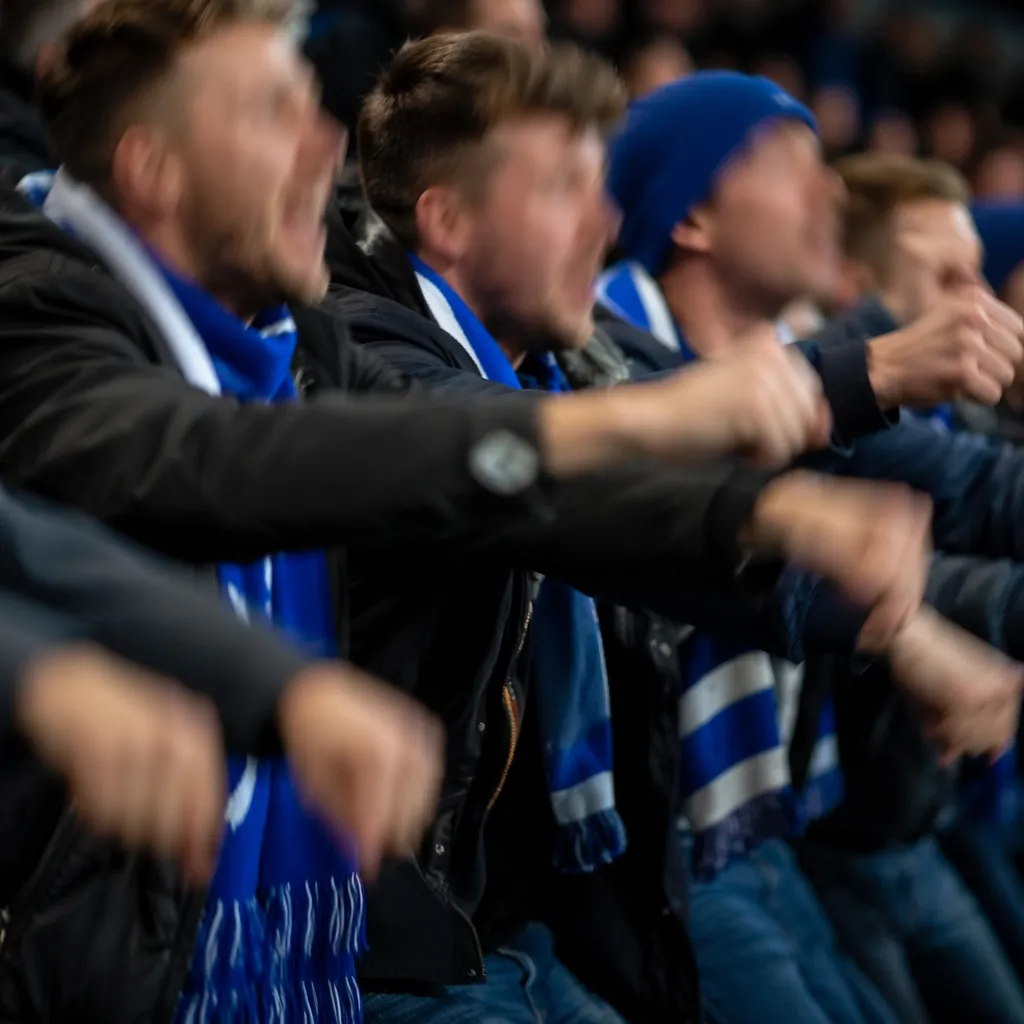 Close up candid shot of football fans performing viking rowing gesture together,