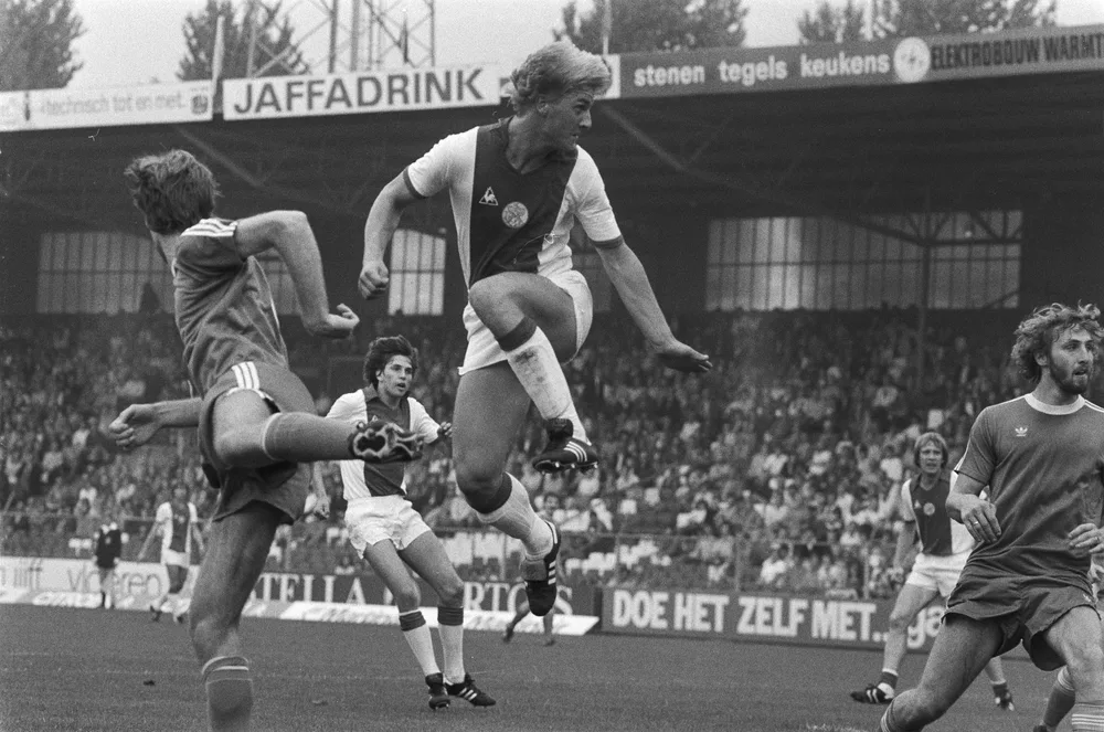 Close up shot of generic football boots and a leather match ball placed on well-