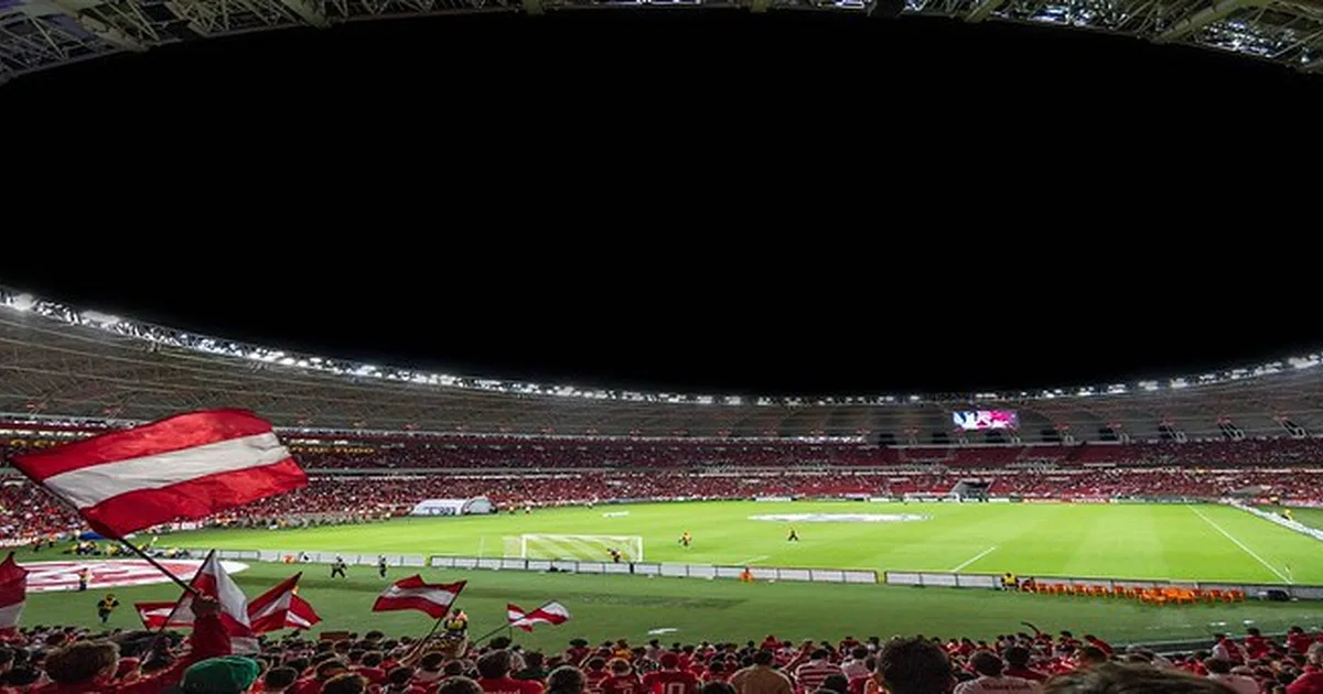 Professional football stadium interior with blue and white team scarves held by cheering f