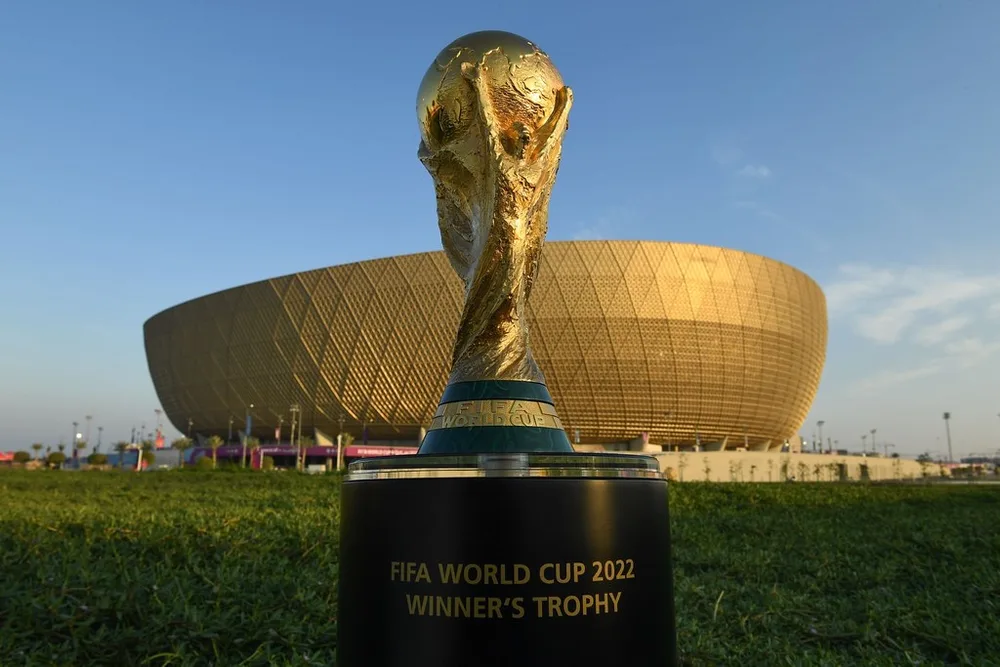 Close-up of the World Cup trophy placed on a plain presentation podium, soft amb