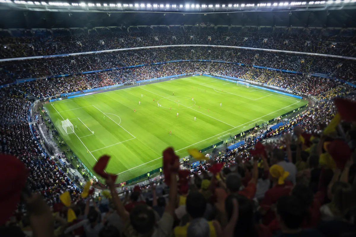 High-angle shot of a modern FIFA World Cup soccer stadium during a match, with blurred che