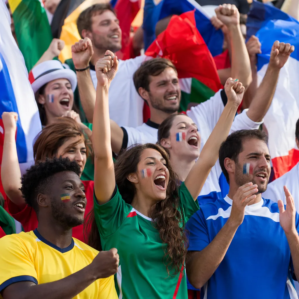 Diverse group of football fans wearing generic national team jerseys cheering in