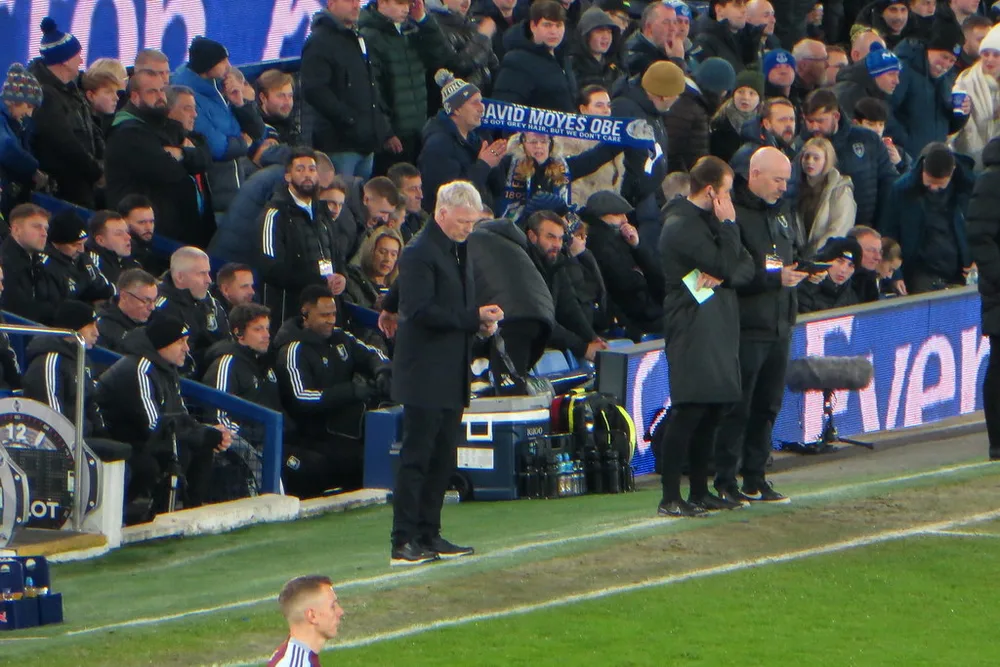 Generic shot of a football manager talking to club officials in a modern confere
