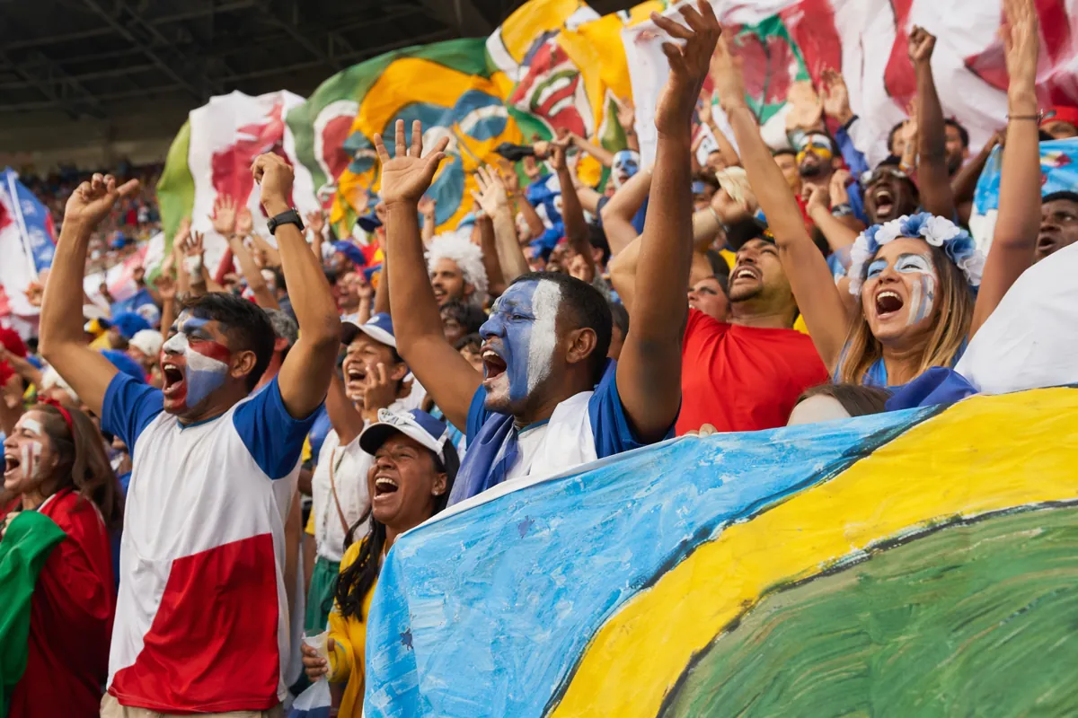Colorful football fans cheering with hand-painted banners in a stadium, vibrant world cup