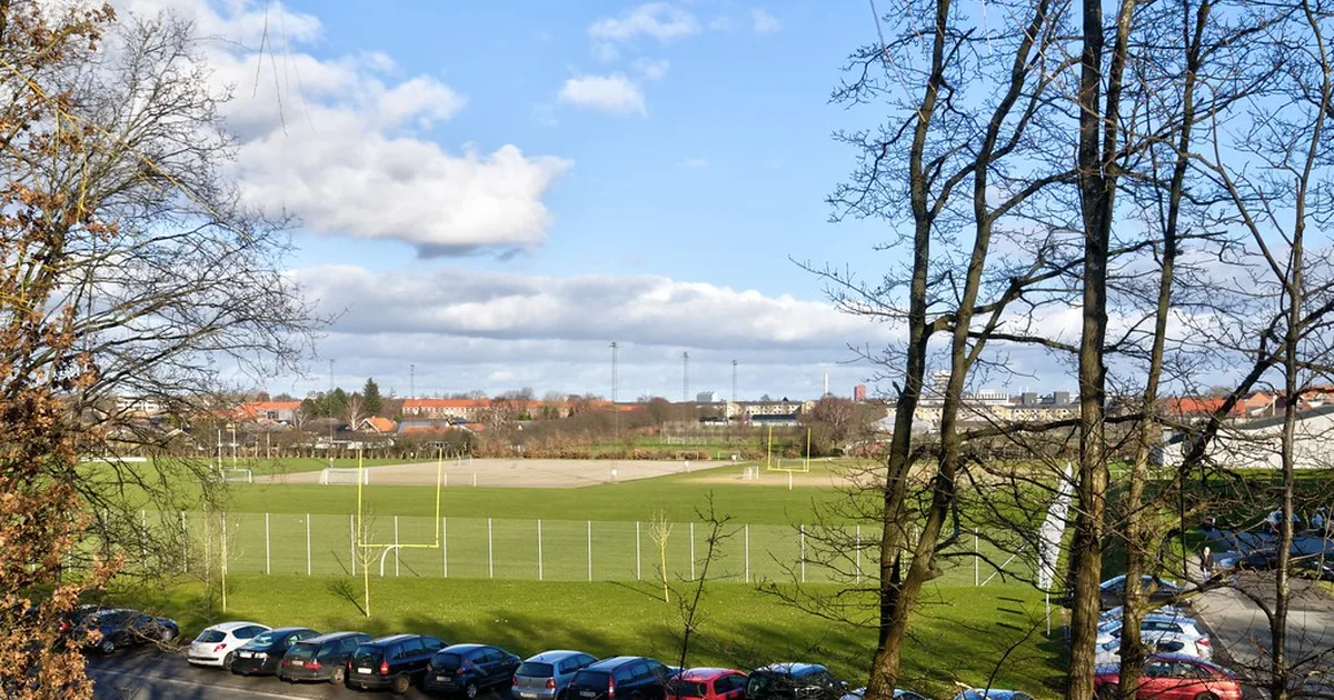 Professional football stadium at dusk with empty green pitch, bright stadium lights, blurr