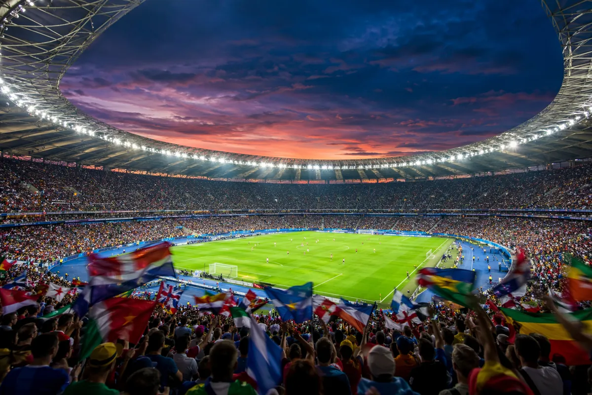 Wide shot of a modern world cup football stadium at twilight, with blurred crowd of fans w