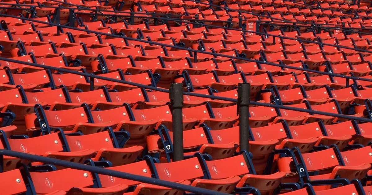 Professional football editorial header image, wide shot of a modern football stadium durin