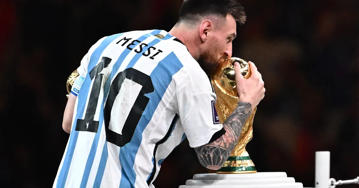 Photojournalistic shot of a golden football trophy placed on a white pedestal in a modern