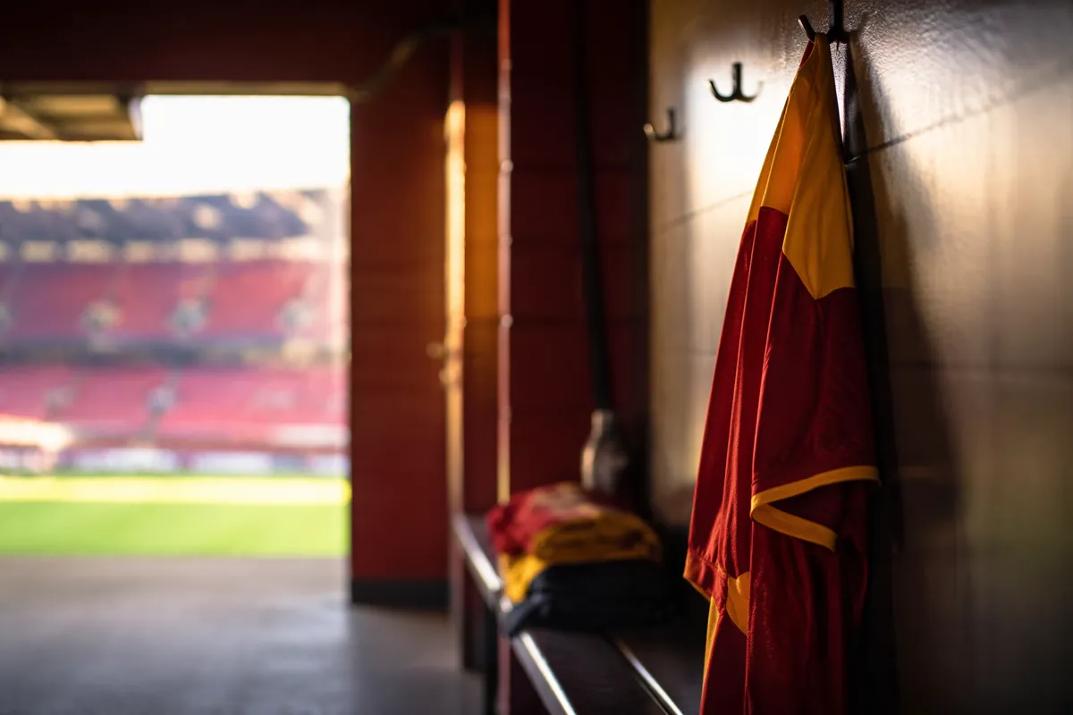 Professional sports news header image, abstract football locker room scene, red and yellow
