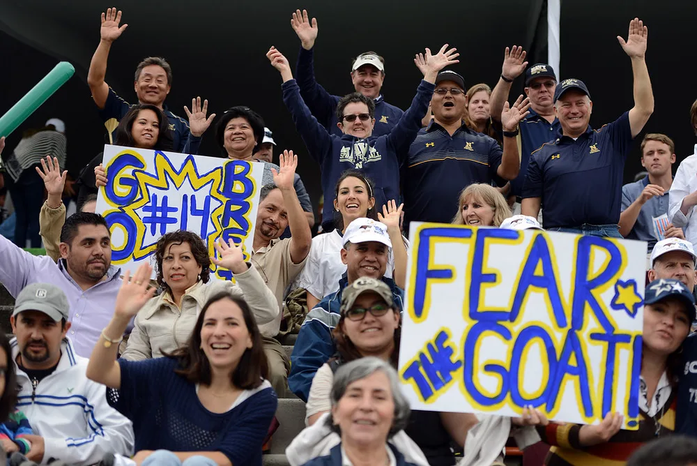 Wide shot of football fans wearing generic national team jerseys cheering in a s