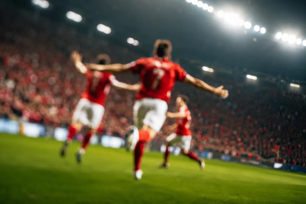 Professional football match action shot, blurred players in red and white jerseys celebrat